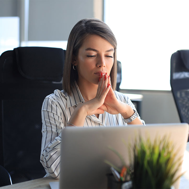 An image showcasing a corporate woman engaged in meditation, promoting mindfulness and stress reduction in the workplace.